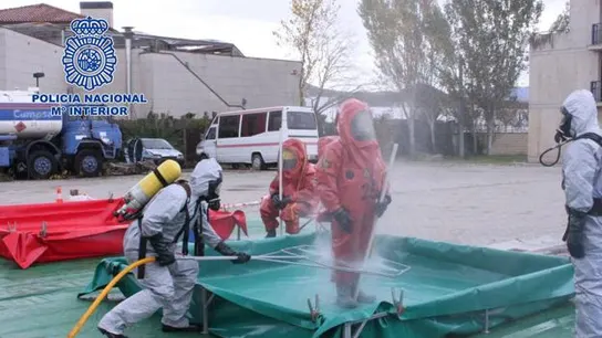Un equipo de los TEDAX desinfectando a agentes de la Policía Nacional Un equipo de los TEDAX desinfectando a agentes de la Policía Nacional