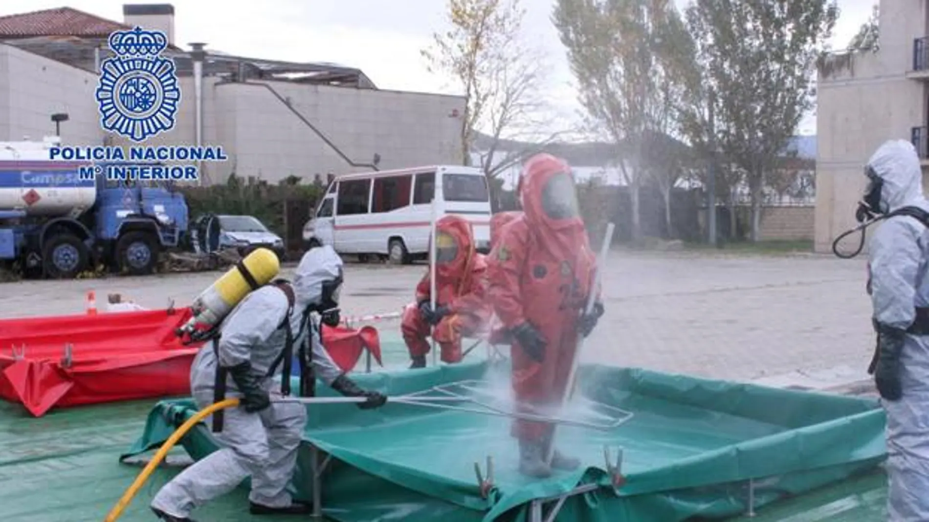 Un equipo de los TEDAX desinfectando a agentes de la Policía Nacional