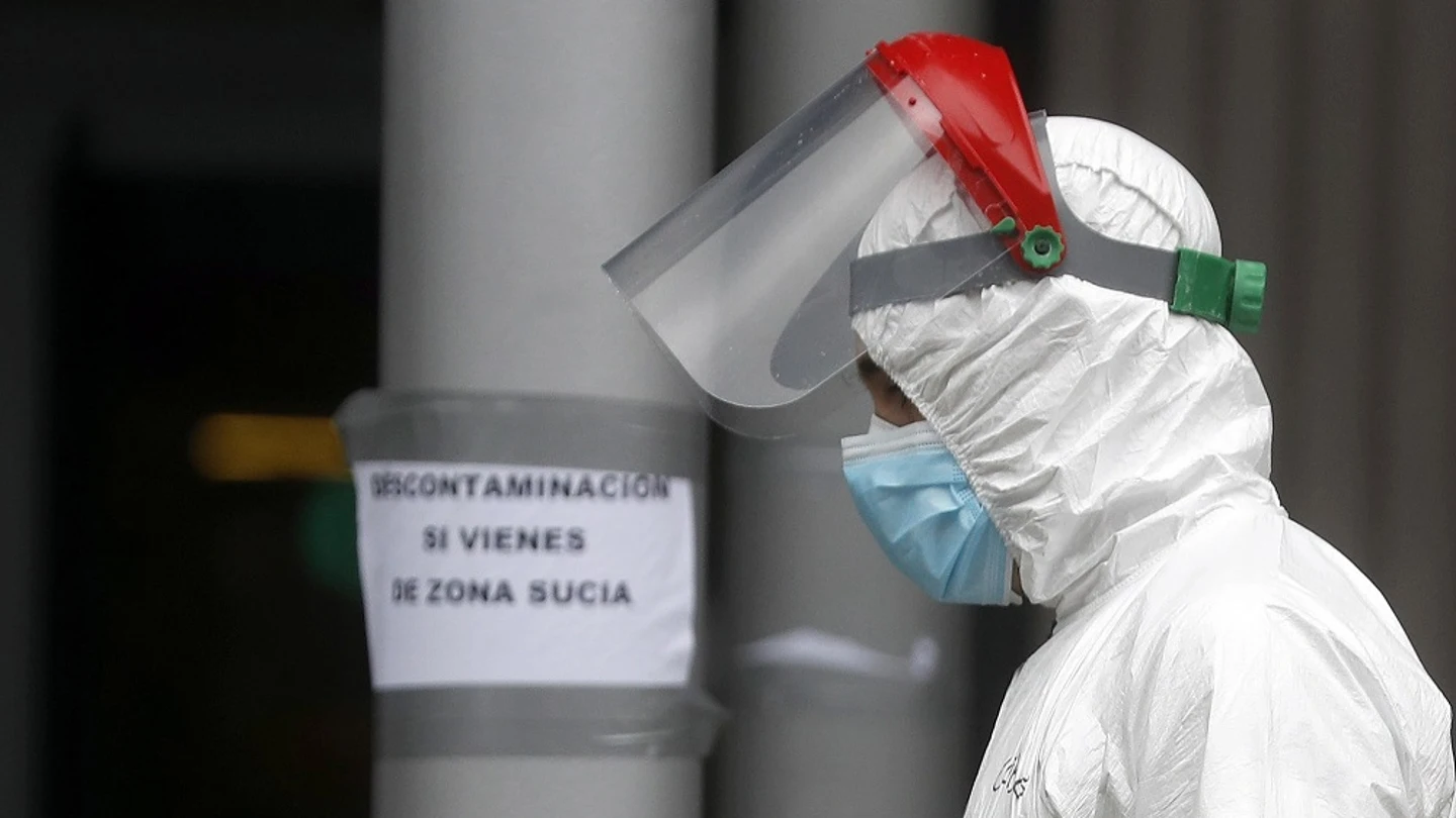 Imagen de un trabajador con el traje de protección cruzando una zona común de Ifema Imagen de un trabajador con el traje de protección cruzando una zona común de Ifema