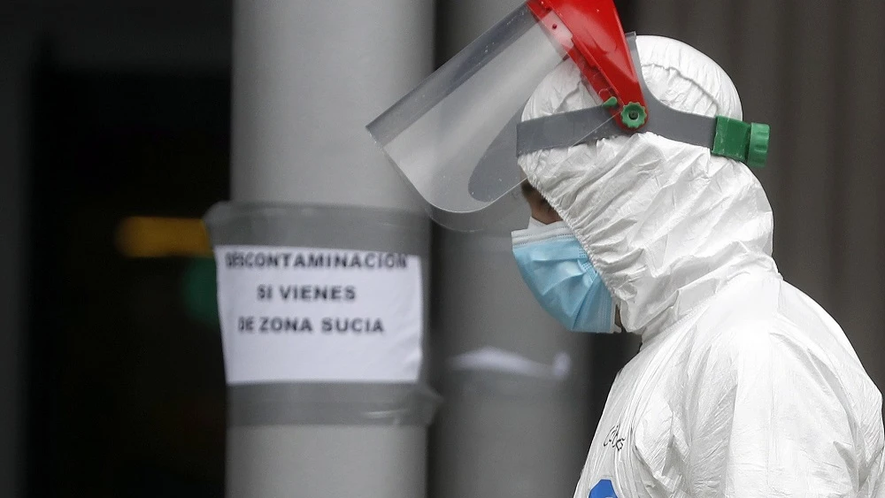 Imagen de un trabajador con el traje de protección cruzando una zona común de Ifema