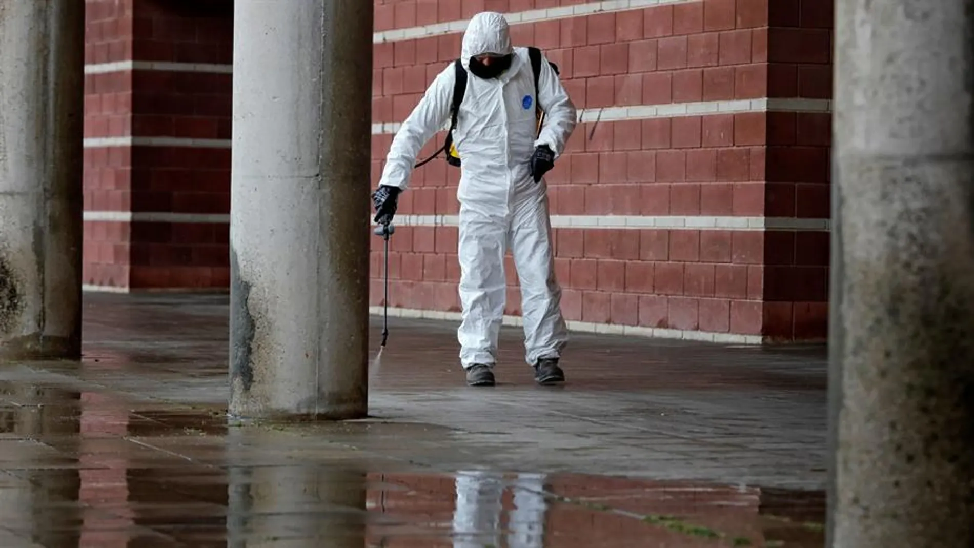 Un operario municipal desinfecta el exterior del pabellón Las Comas donde se ha instalado un hospital de campaña, en Igualada (Barcelona)