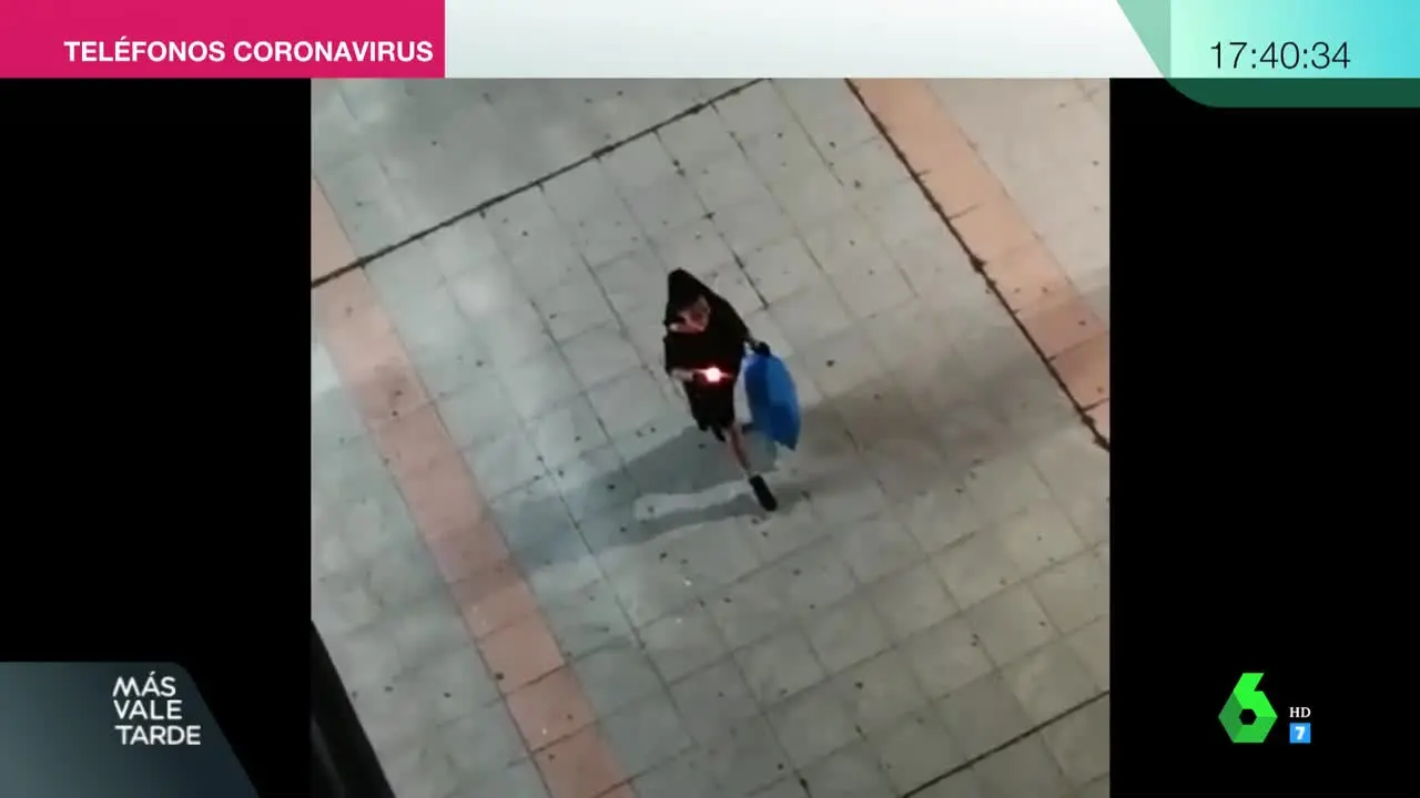 Una mujer aprovecha el momento de bajar la basura para lucir la mantilla.