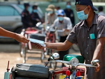 Un conductor recibe una mascarilla gratuita durante una donación de alimentos a personas con bajos ingresos en Myanmar Un conductor recibe una mascarilla gratuita durante una donación de alimentos a personas con bajos ingresos en Myanmar