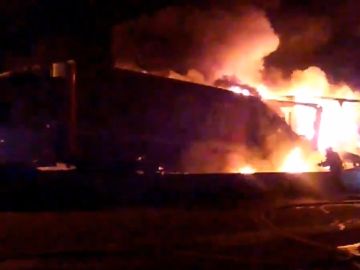 Los bomberos trabajan para detener el fuego desatado en uno de los camiones. Los bomberos trabajan para detener el fuego desatado en uno de los camiones.