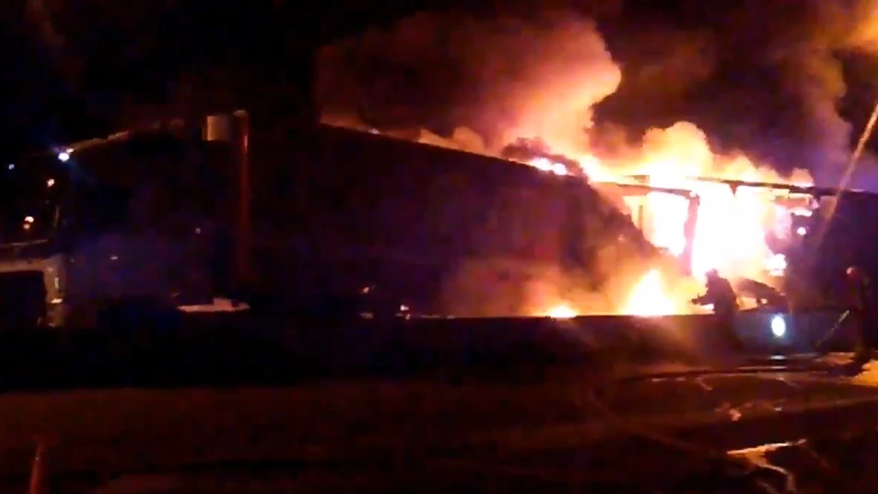 Los bomberos trabajan para detener el fuego desatado en uno de los camiones.