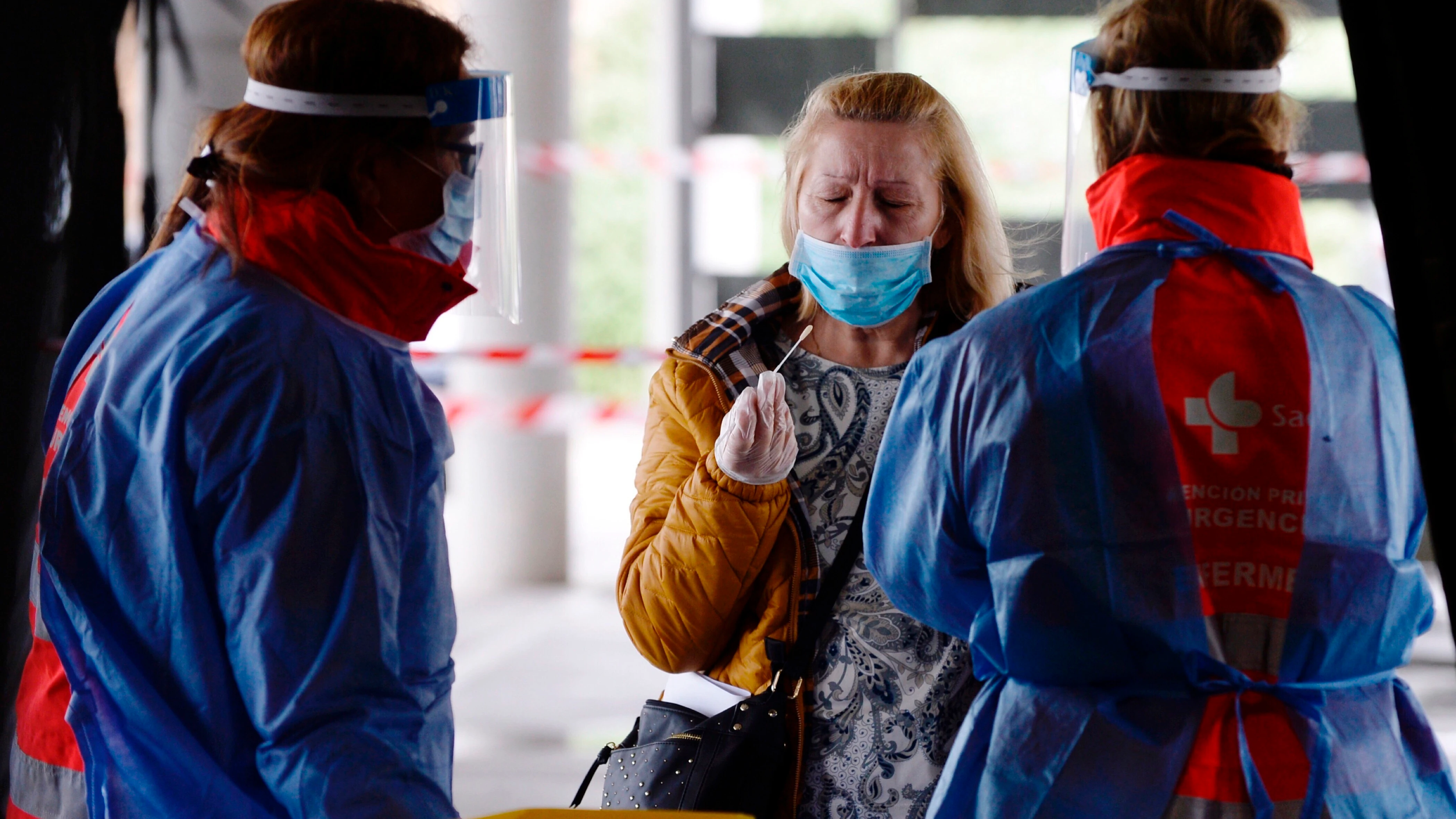 Le toman una muestra a una mujer para realizar el test del coronavirus