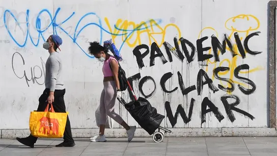 Personas con mascarilla frente a un grafitti sobre el coronavirus en Londres Personas con mascarilla frente a un grafitti sobre el coronavirus en Londres