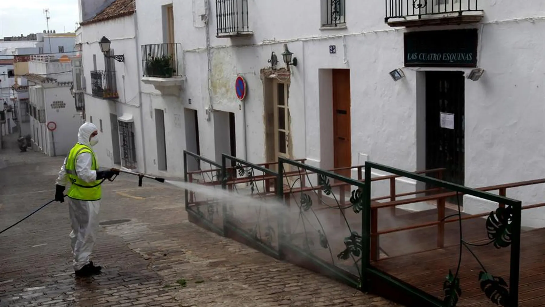 Un operario de limpieza desinfecta una terraza de un bar en Cádiz