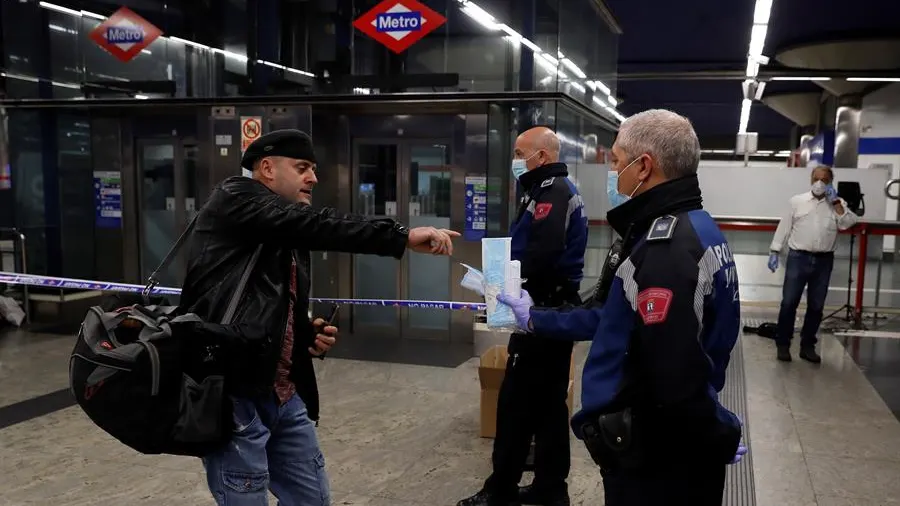 Policías entregan mascarillas en la estación de metro de Nuevos Ministerios en Madrid, este lunes. 