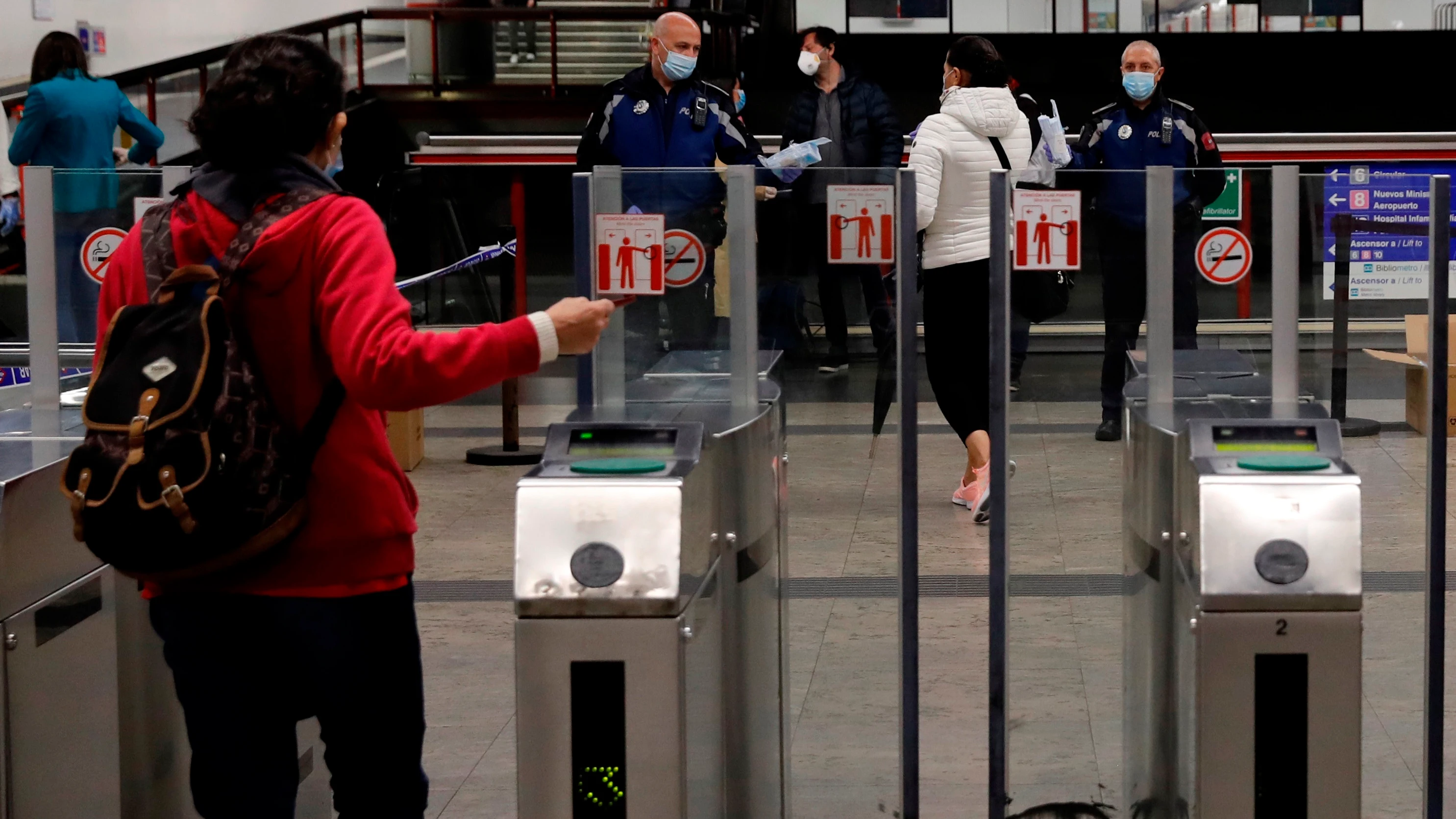 Policías entregan mascarillas en la estación de metro de Nuevos Ministerios en Madrid