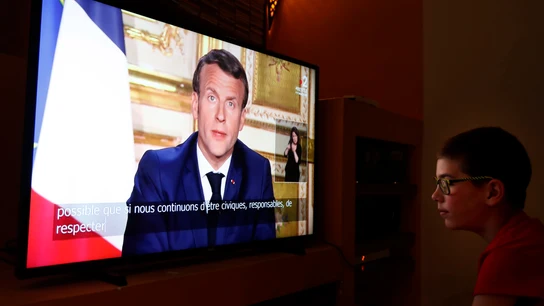 Un joven ve la comparecencia de Emmanuel Macron por televisión Un joven ve la comparecencia de Emmanuel Macron por televisión