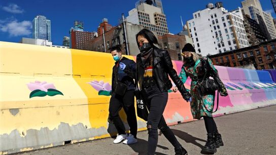 Varias personas caminan por las calles de Nueva York cubri&eacute;ndose la cara
