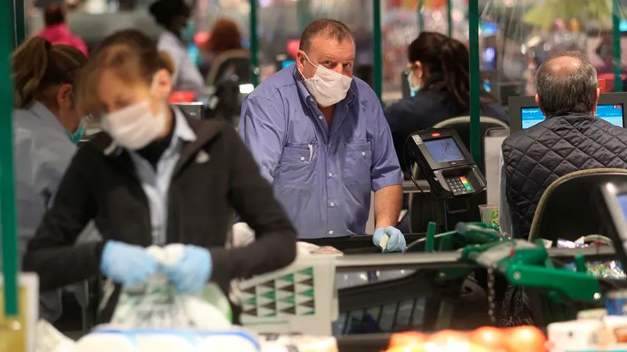 Varias personas hacen la compra en un supermercado de Madrid durante la pandemia de coronavirus