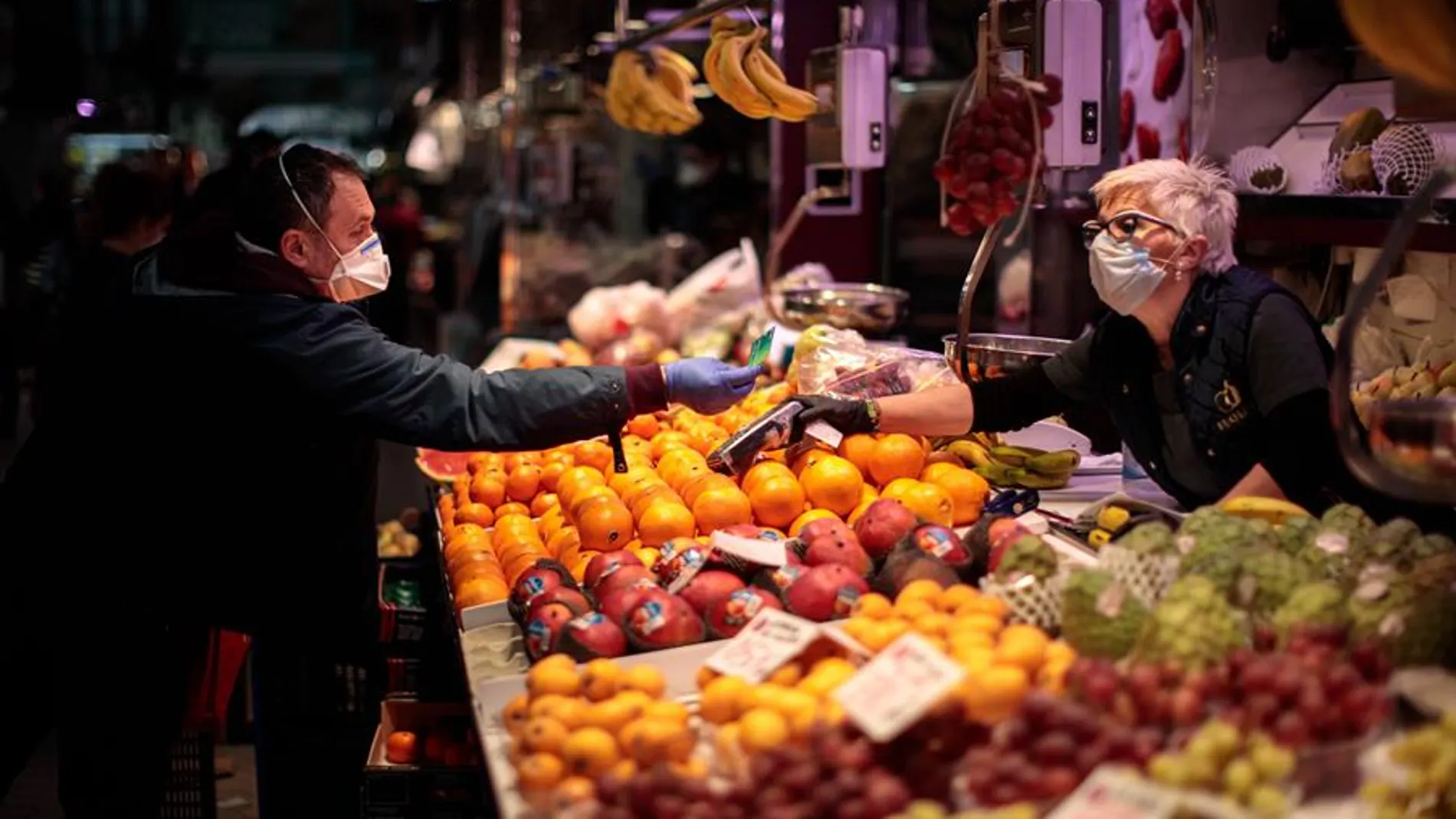 Una persona compra en un puesto de frutas del Mercado Central de Valencia