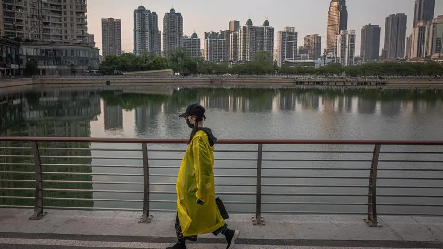 Una mujer camina junto a un lago de Wuhan (China) Una mujer camina junto a un lago de Wuhan (China)