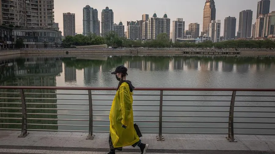 Una mujer camina junto a un lago de Wuhan (China)