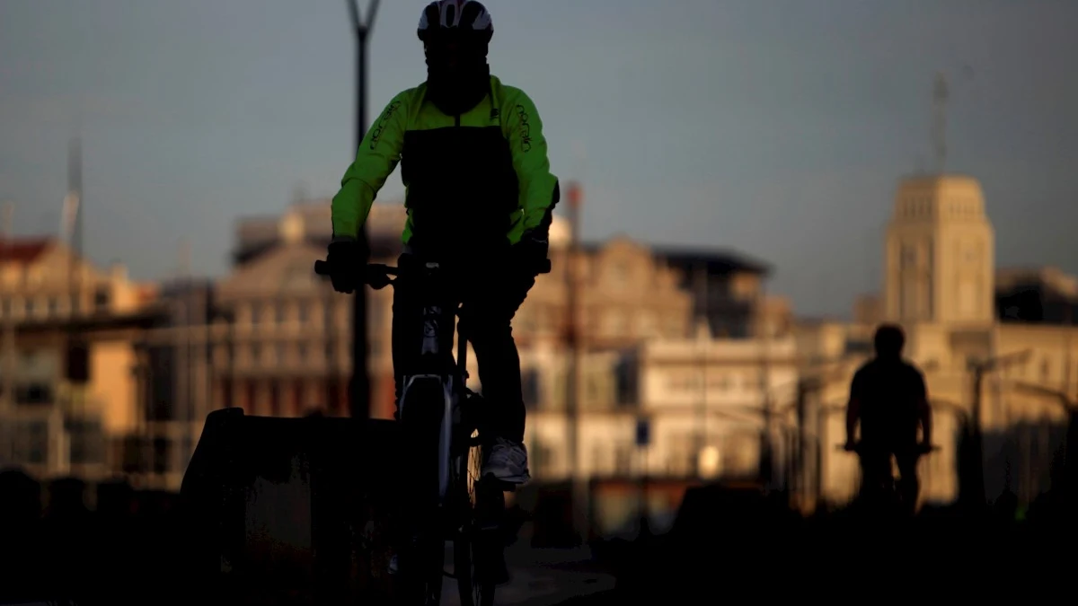 Un hombre en bicicleta circulaba hoy domingo por el paseo marítimo de A Coruña