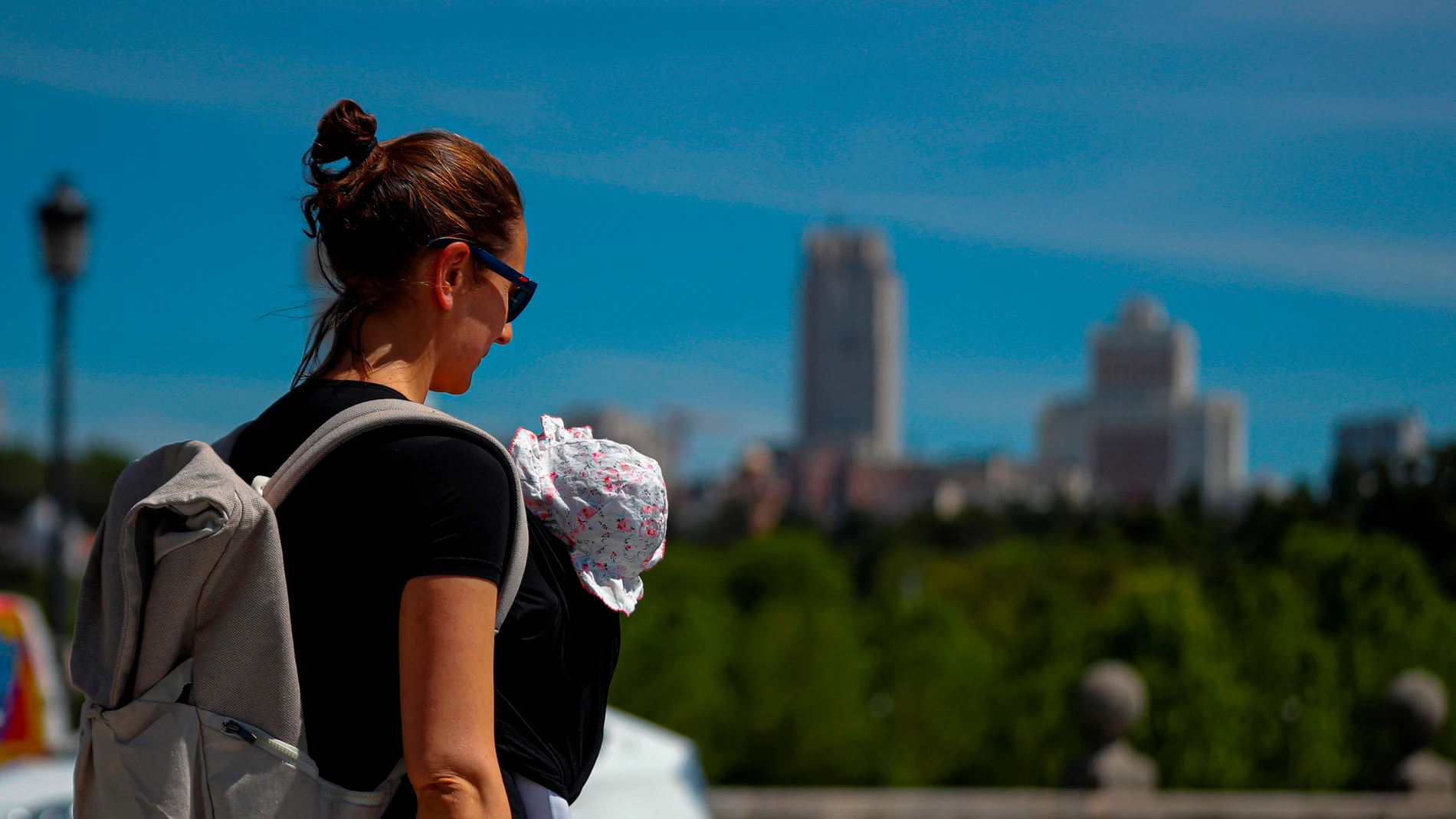 Una madre pasea con su bebé en Madrid durante el Día de la Madre