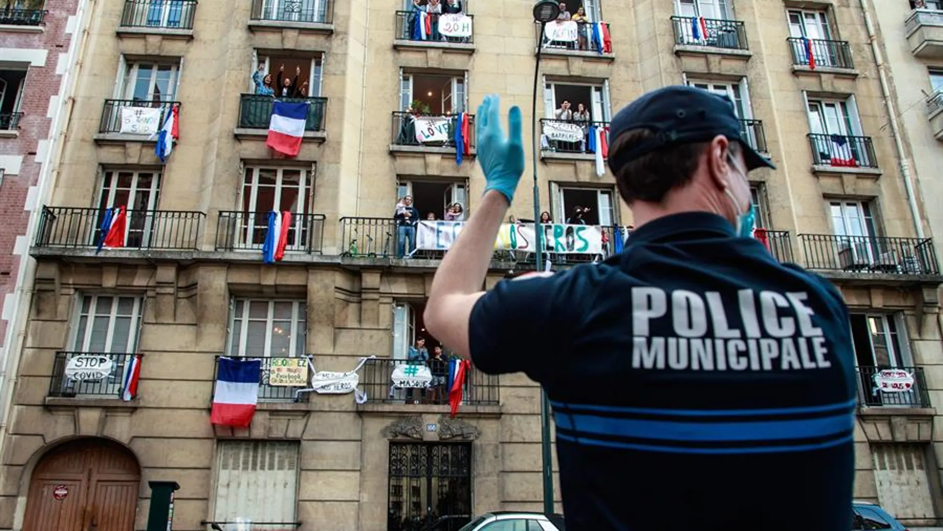 Un oficial de Policía aplaude frente a un edificio en Francia