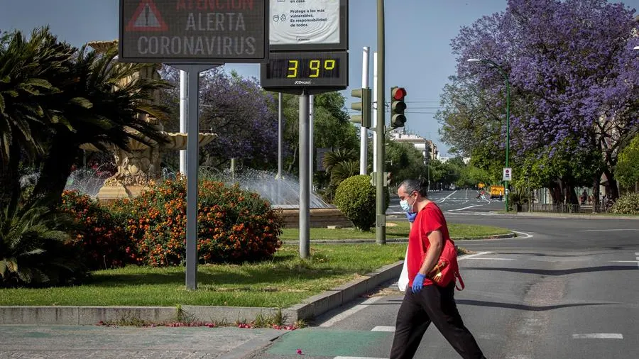 Un hombre protegido con guantes y mascarilla pasea por Sevilla bajo temperaturas de 39ºC