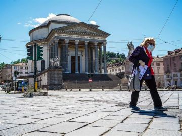 Una mujer protegida con mascarilla camina por las calles de Roma. Una mujer protegida con mascarilla camina por las calles de Roma.
