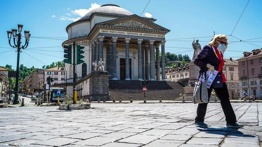 Una mujer protegida con mascarilla camina por las calles de Roma.