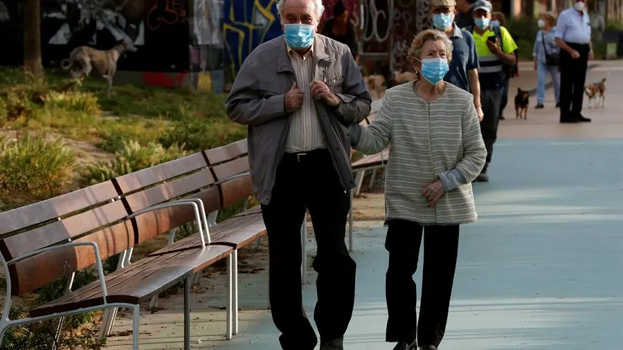 Una pareja protegida con mascarillas pasea por la Rambla Nova de Sants