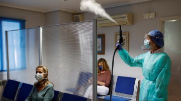Imagen de una empleada de la Clínica Dental Reina Victoria 70 llevando a cabo las medidas de seguridad para posibilitar la reapertura del local en la fase 0 de desescalada por el coronavirus