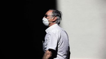 Una persona protegida con mascarilla recorre una calle en Valencia.