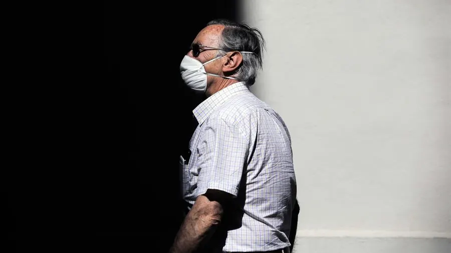 Una persona protegida con mascarilla recorre una calle en Valencia.