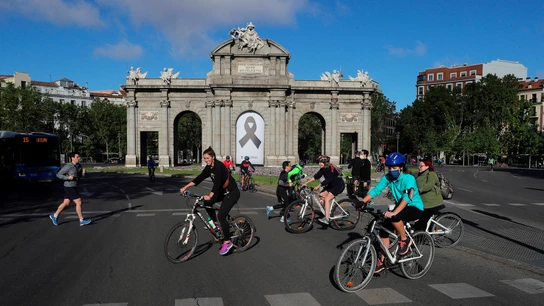 Vista de la Puerta de Alcalá con un crespón negro junto a la gente haciendo deporte en Madrid madrid