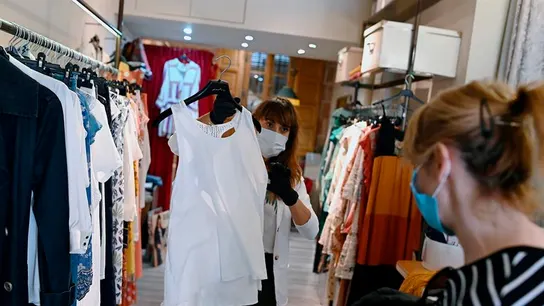 Una trabajadora muestra ropa a una clienta en un comercio de Alcalá de Henares, Madrid Una trabajadora muestra ropa a una clienta en un comercio de Alcalá de Henares, Madrid