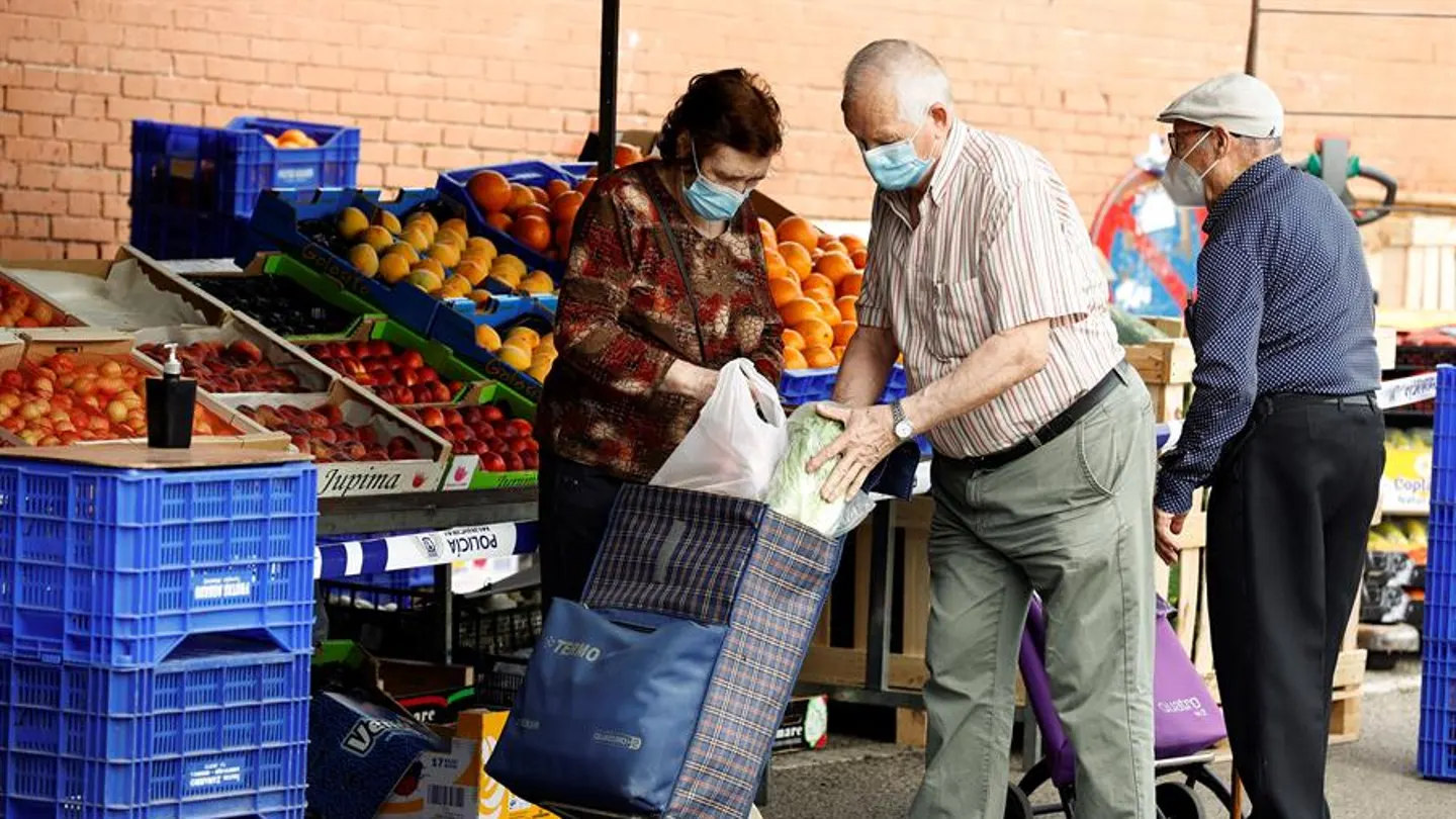 Varias personas hacen sus compras en un mercadillo en Madrid Varias personas hacen sus compras en un mercadillo en Madrid