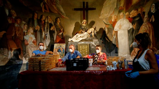 Varios voluntarios preparan la comida que repartirán al día siguiente a más de 200 personas en una capilla de Barcelona Ayuda