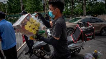 Un repartidor en Pekín con mascarilla