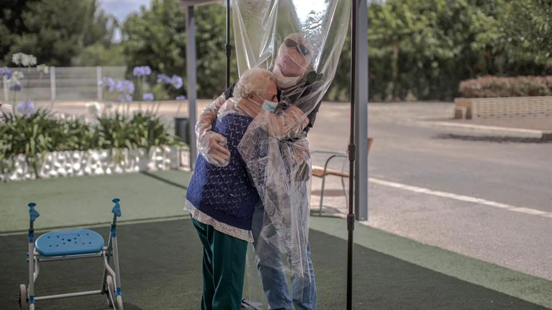 Una interna en una residencia de mayores abraza a su hijo a través de un plástico tras meses de separación por el Covid