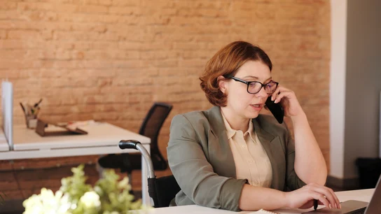 Una mujer hablando por teléfono en la oficina Una mujer hablando por teléfono en la oficina