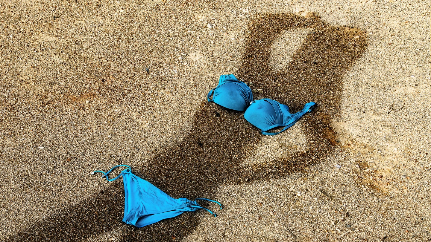 Sombra de una mujer proyectada sobre la arena en la playa Sombra de una mujer proyectada sobre la arena en la playa