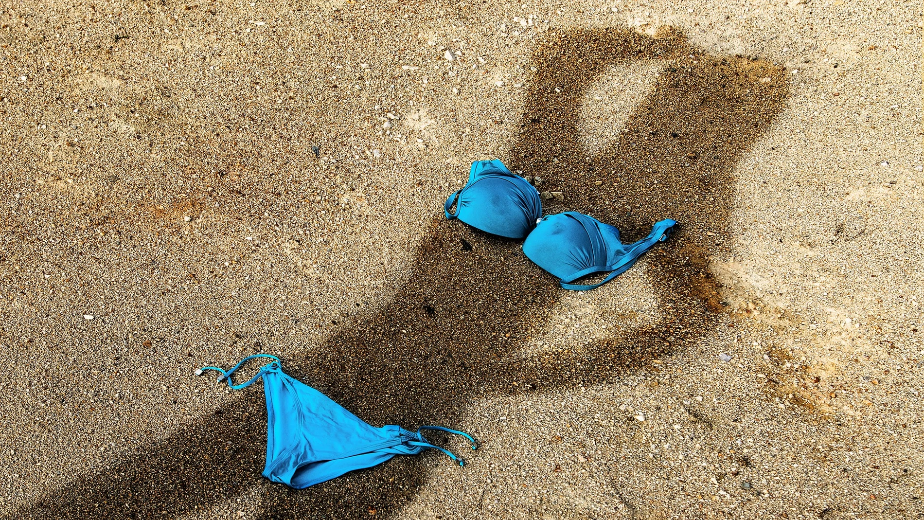 Sombra de una mujer proyectada sobre la arena en la playa
