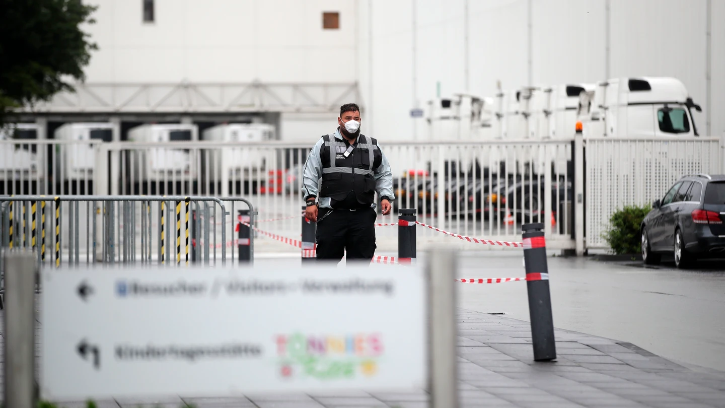 Un empleado de seguridad a las puertas de la fábrica cárnica en Alemania Un empleado de seguridad a las puertas de la fábrica cárnica en Alemania