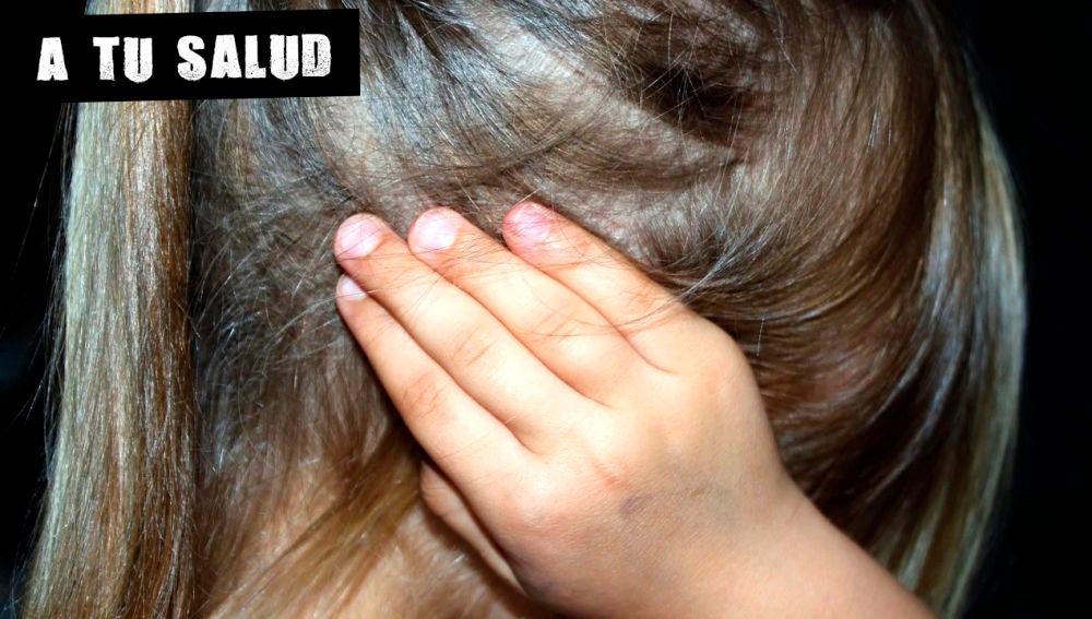Imagen de archivo de una niña con la mano en la oreja