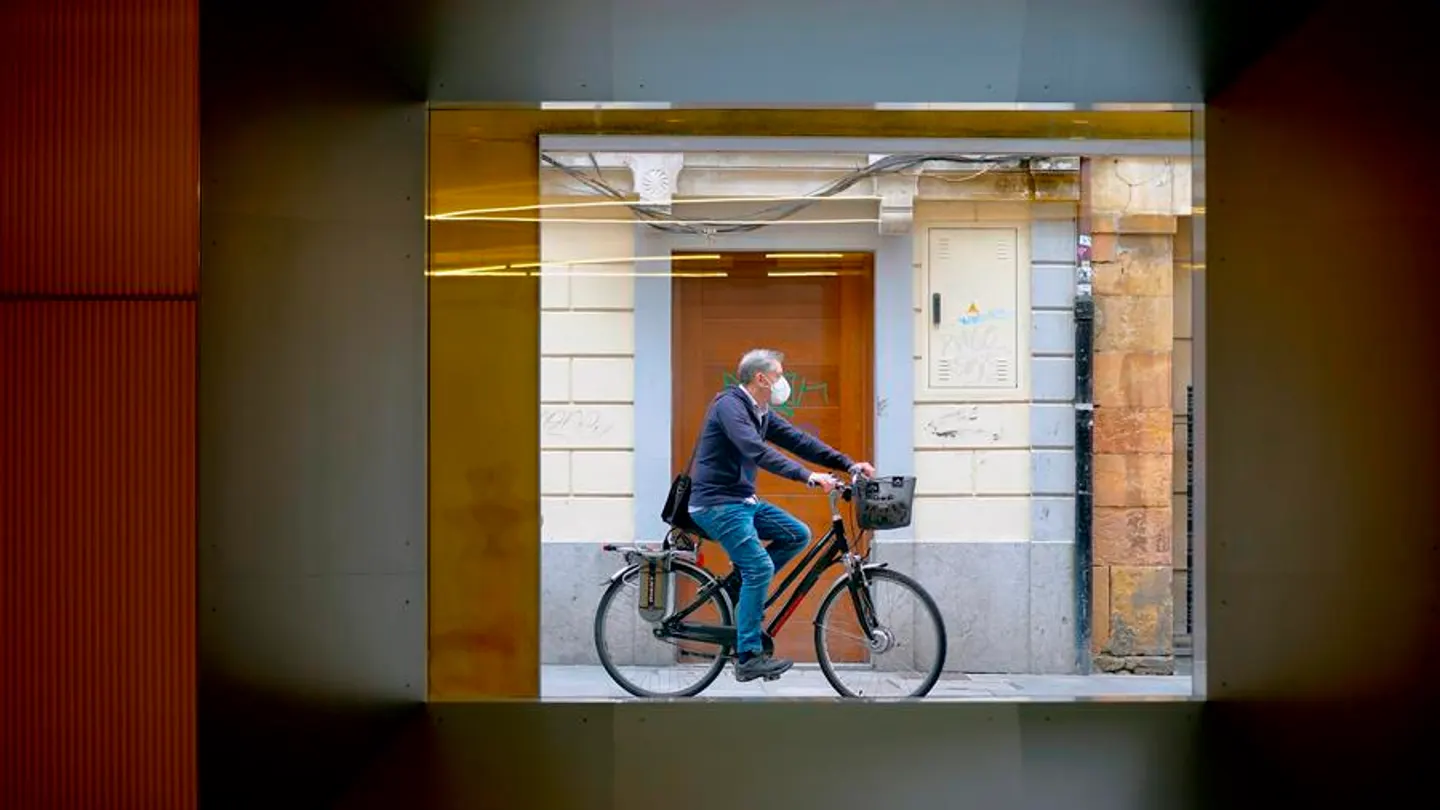 Un hombre con mascarilla pasea en bicicleta Un hombre con mascarilla pasea en bicicleta por Oviedo