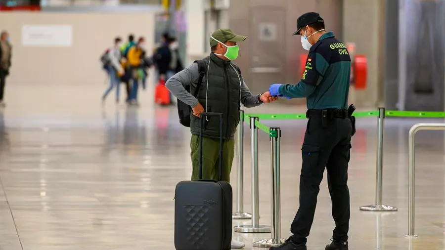 Un pasajero con mascarilla a su llegada al Aeropuerto de Barajas