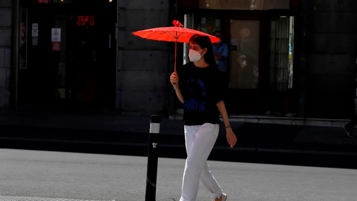 Una mujer se protege del sol con una sombrilla en el centro de Madrid. Una mujer se protege del sol con una sombrilla en el centro de Madrid.
