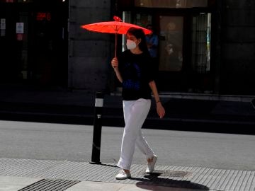 Una mujer se protege del sol con una sombrilla en el centro de Madrid. Una mujer se protege del sol con una sombrilla en el centro de Madrid.