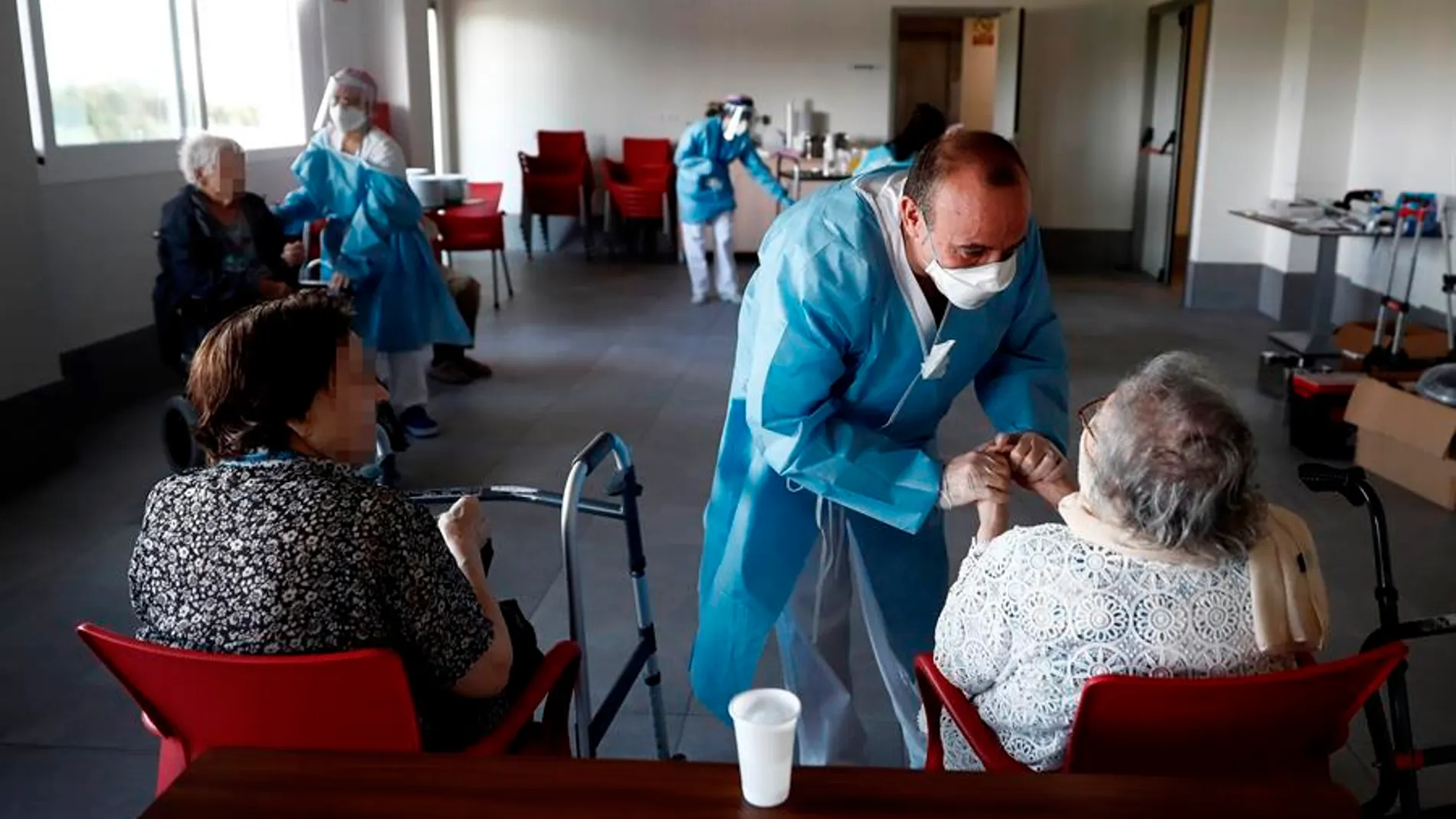 Un sanitario atiende a los ancianos alojados en una residencia