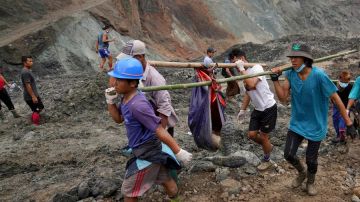 Voluntarios llevan el cuerpo de una víctima después de un deslizamiento de tierra en una mina de jade en Hpakant, estado de Kachin, Myanmar, 