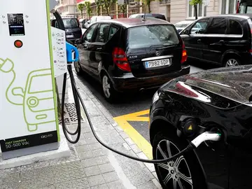 Coche enchufado a una estación de carga Coche enchufado a una estación de carga