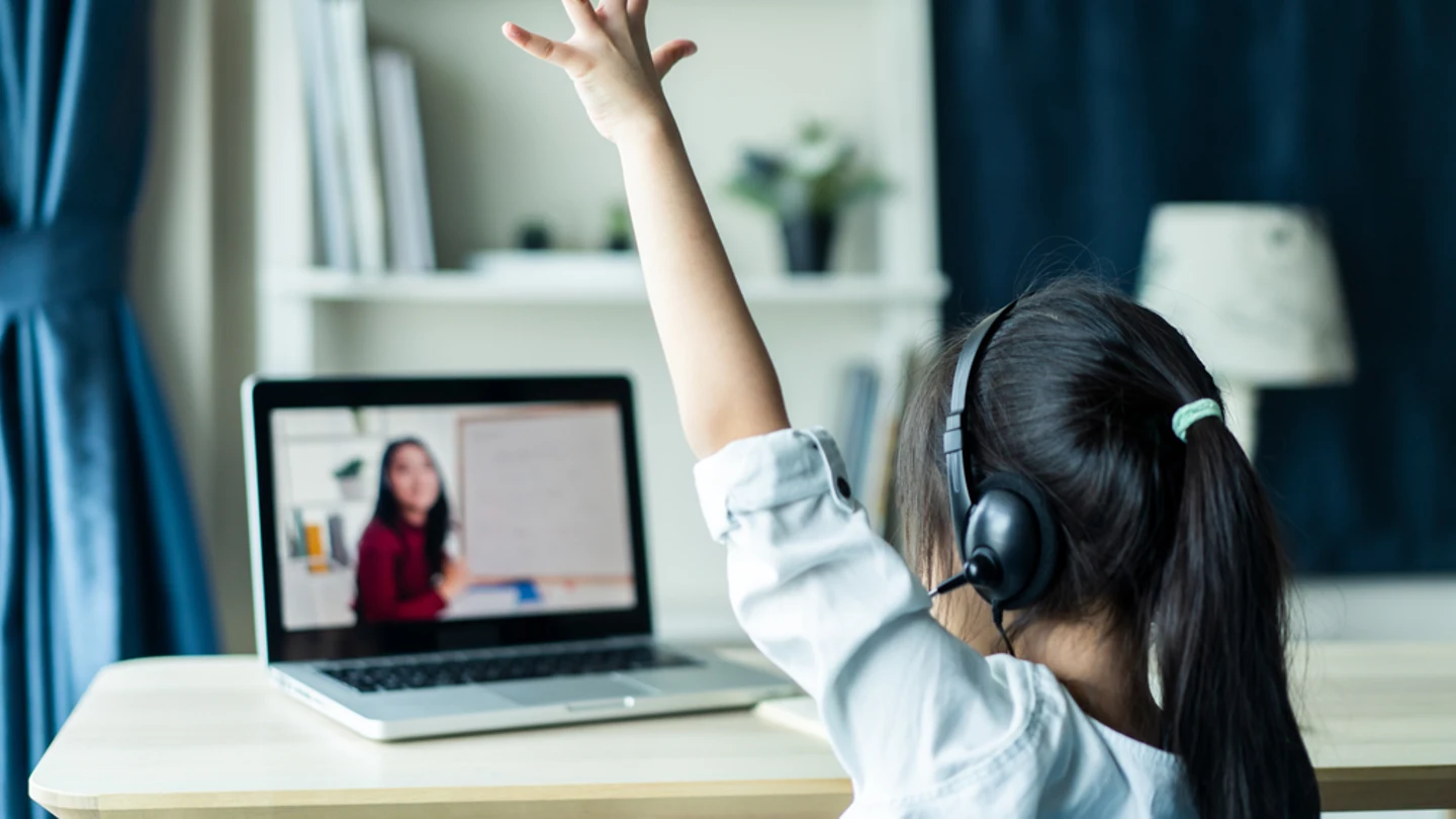 Así está afectando el covid a la educación española: abandono, más desigualdad y trastornos psicológicos Niña levanta la mano mientras atiende en una clase 'online'