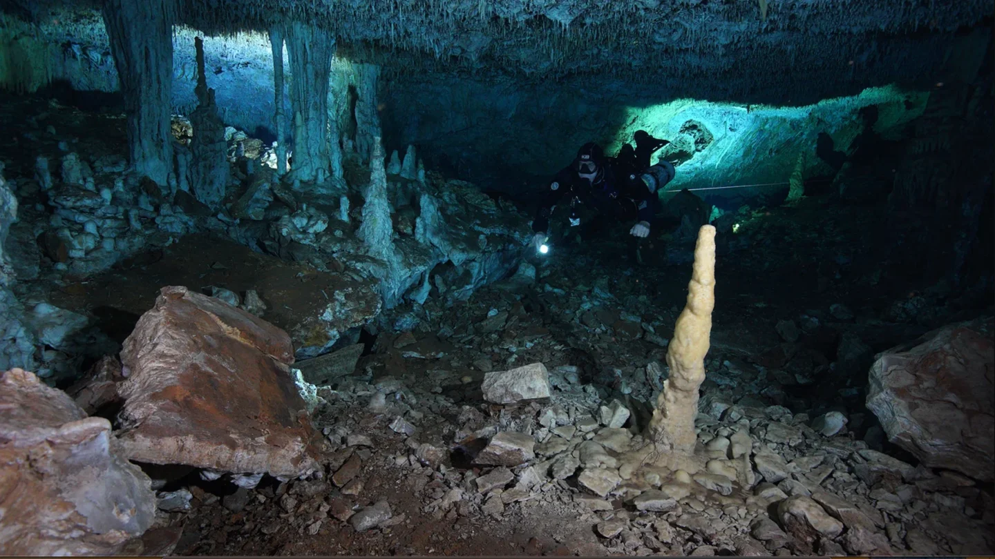 Buceador investigando la cueva de la explotación minera de ocre Buceador investigando la cueva de la explotación minera de ocre